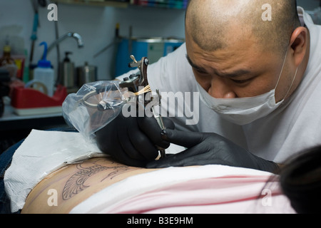 Junge, weibliche tattoo taiwanesischen chinesische empfangen unteren Rücken aus asiatischen Mann mit rasierten Kopf, Taipei Taiwan Volksrepublik China ROC Stockfoto