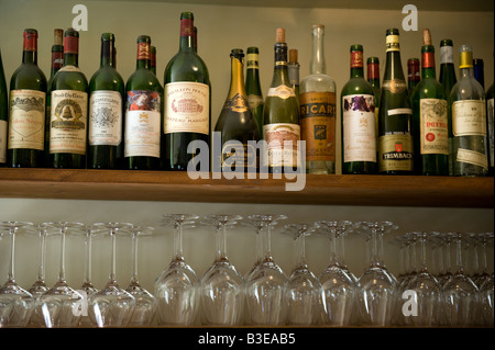 Weinflaschen & Gläser im Regal Stockfoto