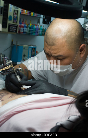 Junge, weibliche tattoo taiwanesischen chinesische empfangen unteren Rücken aus asiatischen Mann mit rasierten Kopf, Taipei Taiwan Volksrepublik China ROC Stockfoto