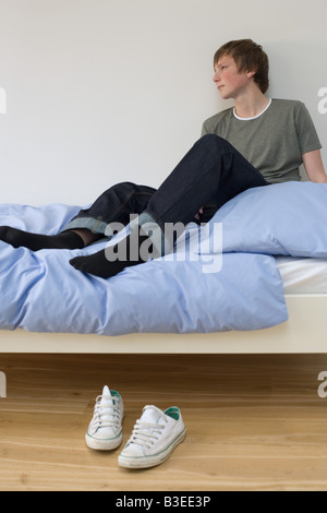 Ein Junge sitzt auf einem Bett Stockfoto