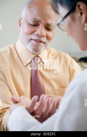 Ein Arzt untersucht eine Patienten-hand Stockfoto