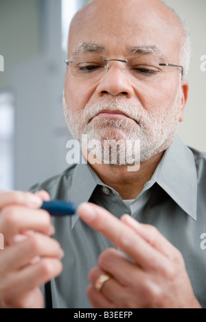 Ein Mann ein Haus Blut Glukose Tests Stockfoto