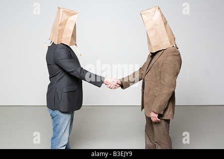 Männer mit Papiertüten auf ihren Köpfen Stockfoto