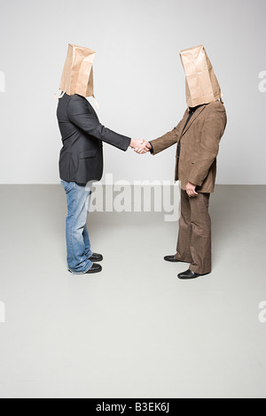 Männer mit Papiertüten auf ihren Köpfen Stockfoto