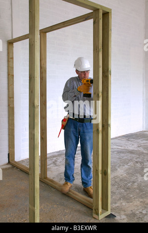 Tischler, Bohren in einigen Fachwerk in ein neues Haus zu bauen Stockfoto
