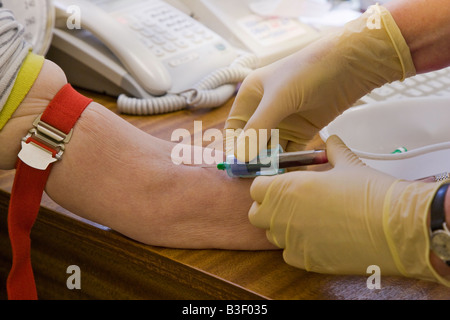 EINNAHME-BLUT VOM ARM DER ÄLTEREN FRAU ALTER 60ER JAHRE Stockfoto