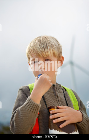 Junge (7-9) bläst Spielzeug Pfeife am Windpark, Porträt Stockfoto