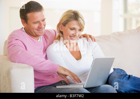 Paar im Wohnzimmer mit Laptop und lächelnd Stockfoto