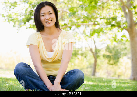 Frau sitzt im freien Lächeln Stockfoto