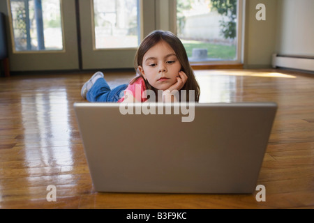 Junges Mädchen (5-6) auf Boden mit laptop Stockfoto