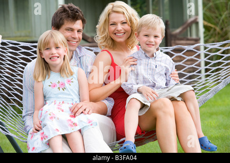 Familie sitzt in der Hängematte zu Lächeln Stockfoto