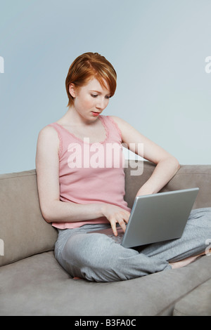 Frau mit Laptop auf sofa Stockfoto