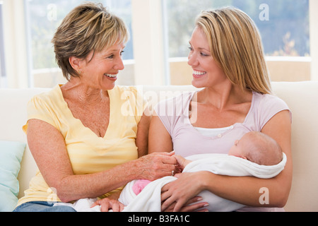 Großmutter und Mutter im Wohnzimmer mit Baby Lächeln Stockfoto