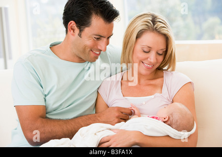 Paar im Wohnzimmer mit Baby Lächeln Stockfoto