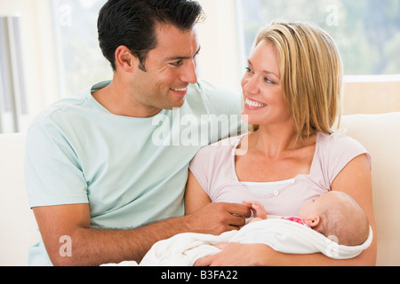 Paar im Wohnzimmer mit Baby Lächeln Stockfoto