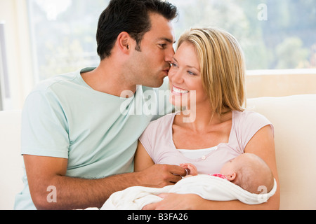 Paar im Wohnzimmer mit Baby Lächeln Stockfoto