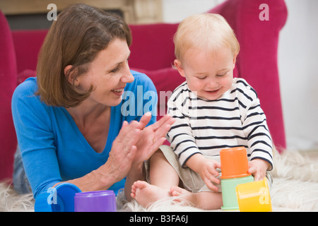 Mutter im Wohnzimmer spielen mit Baby Lächeln Stockfoto