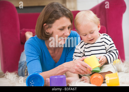 Mutter im Wohnzimmer spielen mit Baby Lächeln Stockfoto