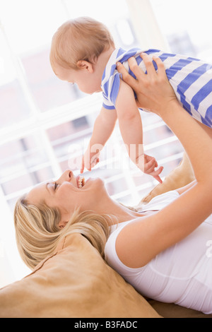 Mutter im Wohnzimmer halten Baby Lächeln Stockfoto