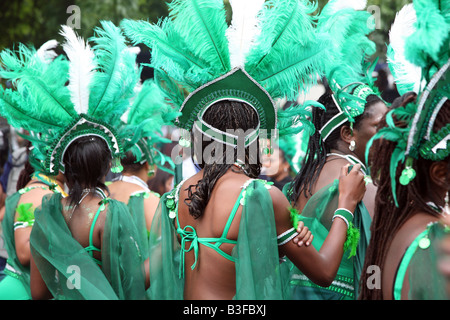 Tänzerinnen in grünen Federkostümen beim Notting Hill Carnival, London, — pulsierende multikulturelle Straßenfeier Stockfoto