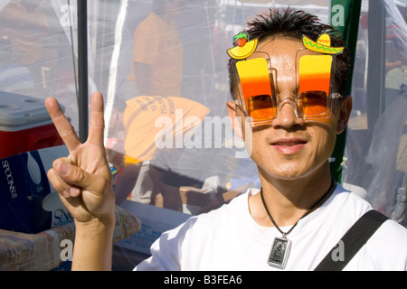 Hmong Mann trägt 21 Jahre Insel Sonne Brille gibt Friedenssymbol. Hmong Sport Festival McMurray Feld St Paul Minnesota USA Stockfoto