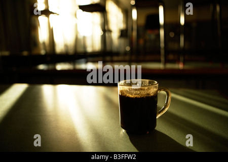 Morgenkaffee auf einem Lehrer s Tisch im Wissenschaftslabor mit Hocker, auf den Bänken Stockfoto