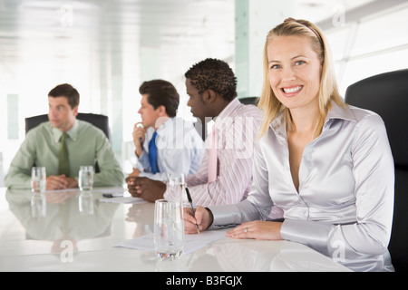 Vier Unternehmer in einem Sitzungssaal lächelnd Stockfoto