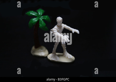 Weiße ägyptische Mumie und Dattelpalme Baum Spielzeug Statue für Halloween Geschenk oder eine Idee für Parteikostüm 2009 auf schwarzem Hintergrund Stockfoto