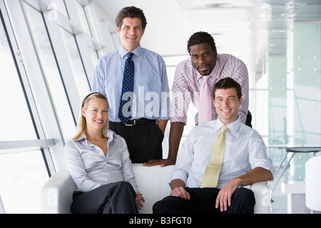 Vier Unternehmer im Büro Lobby lächelnd Stockfoto
