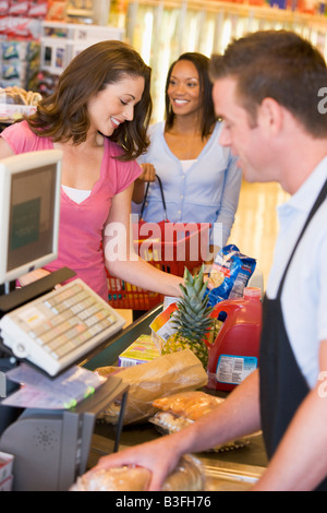 Frauen zahlen für Einkäufe in einem Lebensmittelgeschäft Stockfoto