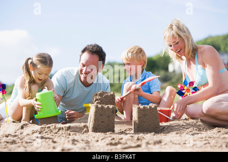 Familie am Strand Sandburgen Lächeln machen Stockfoto