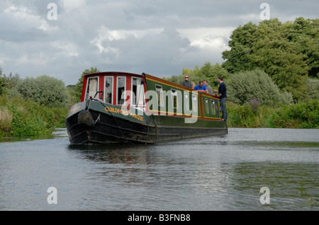 Gruppe von Freunden auf einem Narrowboat über den Fluss Wey Navigation oben Pyrford, Surrey, England Stockfoto