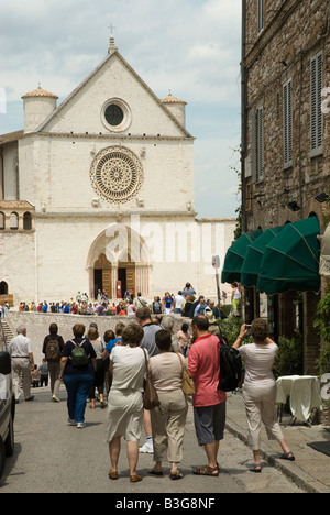 Touristen in Massen AtBasilica des Heiligen Franziskus in Assisi. Das Franziskanerkloster (Sacro Convento) und die untere und obere Kirche (Basilica Inferiore e Superiore) des St. Francis wurde sofort nach seiner Heiligsprechung im Jahre 1228 begonnen. Simone di Pucciarello spendete das Land für die Kirche, einem Hügel an der Westseite von Assisi, bekannt als "Hügel der Hölle" (IT. Collo-d'Inferno - hier die Verbrecher zu Tode gebracht wurden). Dieser Hügel wird heute treffend "Hill of Paradise" genannt. Stockfoto