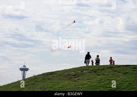 Fliegende Drachen auf einem Hügel am Gasworks Park in Seattle, Washington, am oberen Rand der Space Needle im Hintergrund. Stockfoto