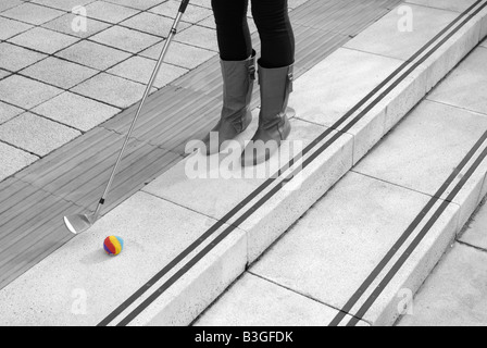 Eine junge Frau urban Golf spielen in der Stadt Stockfoto