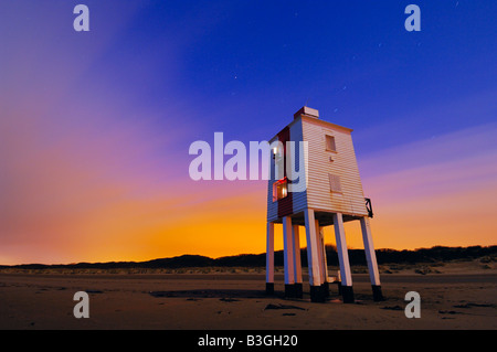 Die hölzernen Leuchtturm in Burnham-on-Sea in der Nacht. Die Wolke am Himmel ist von Lichtverschmutzung in der Nähe von Straßenlaternen beleuchtet. Der Leuchtturm von beiden der Mond und die Lichter der Stadt von Burnham-on-Sea beleuchtet. Somerset, England. Stockfoto