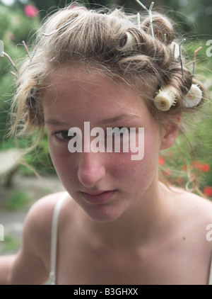 Teenager-Mädchen mit Lockenwicklern im Haar Stockfoto