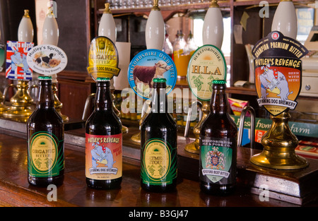 Auswahl von Bierflaschen neben Pumpen auf Bar des Sieges Pub in Hereford England UK hat es eine Brauerei angeschlossen Stockfoto