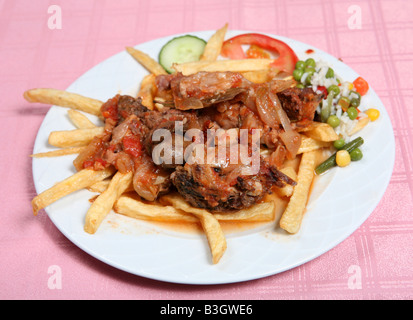 Ein Teller mit Rindfleisch Stifado griechischen Fleisch und Zwiebeln Eintopf mit Pommes frites, Reis und Gemüse Stockfoto