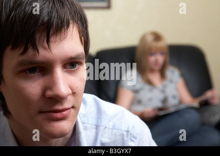 junger Mann und Frau Paar im Wohnzimmer sitzen gelangweilt Stockfoto