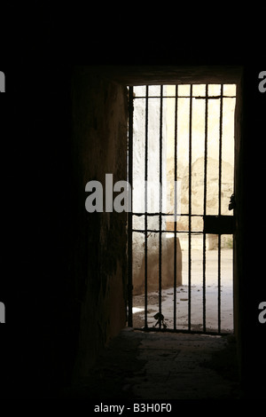 eine einsame Gefängnis Zellentür in dunklen schwarzen Raum Stockfoto