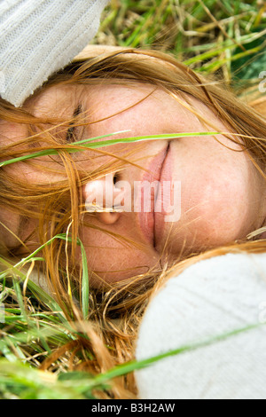 Porträt der attraktive junge rothaarige Frau liegend im Rasen ruhenden hautnah Stockfoto