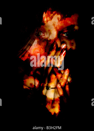 Junge Frau mit Händen und Gesicht bedeckt im Blut Stockfoto