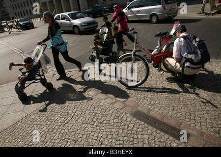 Zwei türkische Frauen mit Kinderwagen die symbolischen Trennungslinie an der Stelle, wo die Berliner Mauer in Berlin, Deutschland war Stockfoto