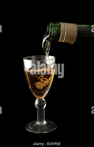 Wein wird in einem Glas schwarz Hintergrund gegossen werden Stockfoto