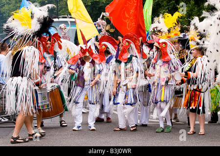 London, Notting Hill Carnival Parade, Tanzgruppe in weißen und roten Huhn Kostüme mit Trommeln und Tamburins Stockfoto