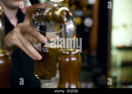 Barkeeper Gießen einen Pint Guinness in einem Pub. Stockfoto