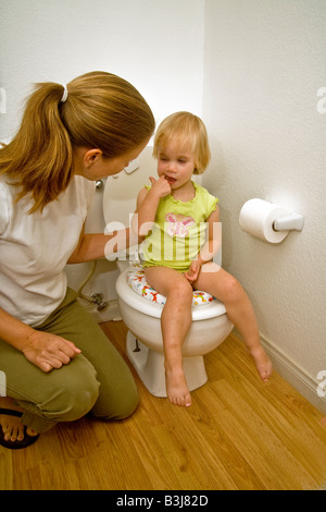 Eine Mutter bringt ihre zwei Jahre alte Tochter Toilettentraining zu Hause in Südkalifornien Stockfoto