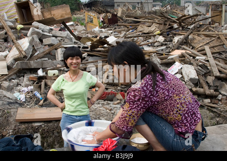 Zwei Überlebende des Erdbebens in Sichuan am 12. Mai 2008 Wäsche außerhalb ihrer zerstörten Gebäude. Stockfoto