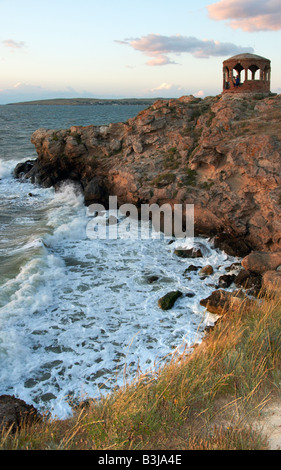 Meer große Surfwelle brechen auf Küste und Cape mit Pavillon in einem Abstand Stockfoto